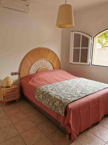 a bedroom with a bed with a wooden head board at Oasis Golf Villa in Caleta De Fuste