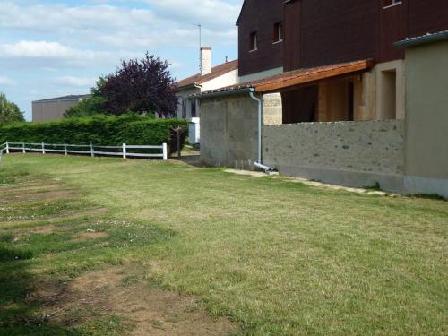 une cour avec une clôture devant une maison dans l'établissement gite ST FIACRE, à Trémont