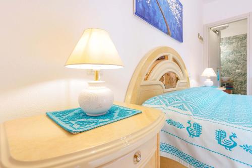 a lamp on a dresser next to a bed at B&B Ametista in Villasimius