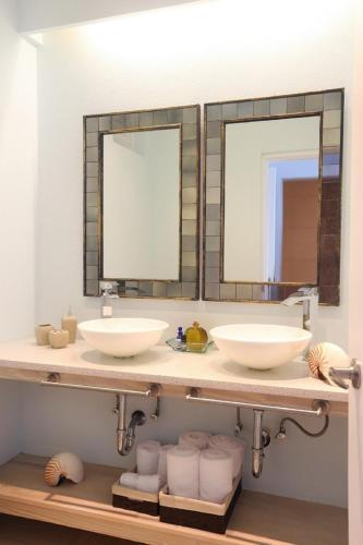 a bathroom with two sinks and two mirrors at Villa with ocean view and infinity pool in Gros Islet