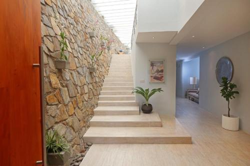 una pared de piedra con escaleras y plantas en un pasillo en Villa with ocean view and infinity pool, en Gros Islet