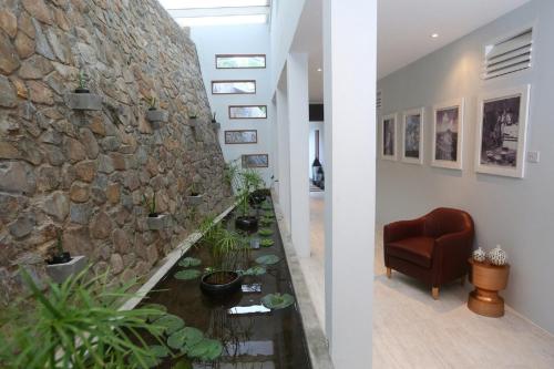 una sala de estar con una pared de piedra y un estanque de peces. en Villa with ocean view and infinity pool en Gros Islet