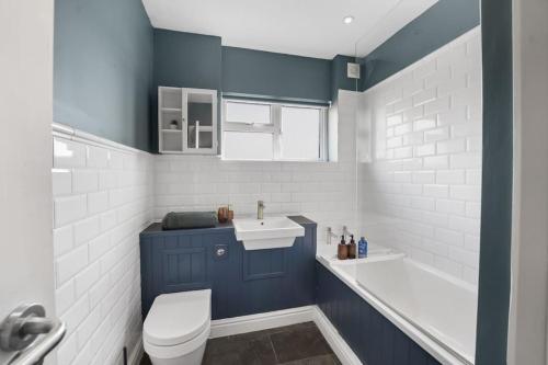 uma casa de banho com um WC, um lavatório e uma banheira em The Beacon, apartment next to the seafront in Herne Bay em Kent