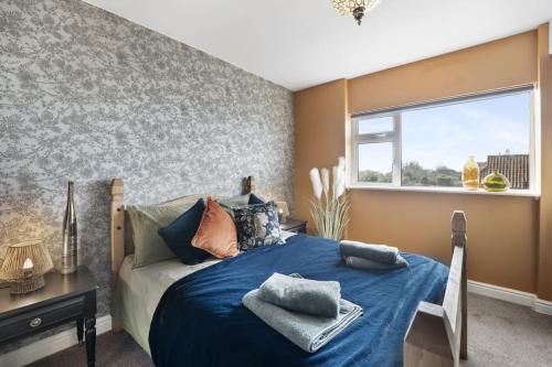 um quarto com uma cama azul e uma janela em The Beacon, apartment next to the seafront in Herne Bay em Kent