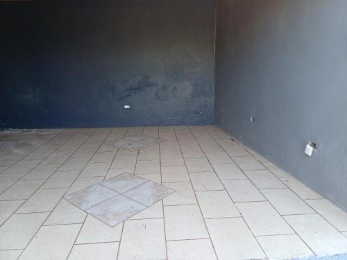 um quarto vazio com piso em azulejo e uma parede em Casa Florencia em Pénjamo