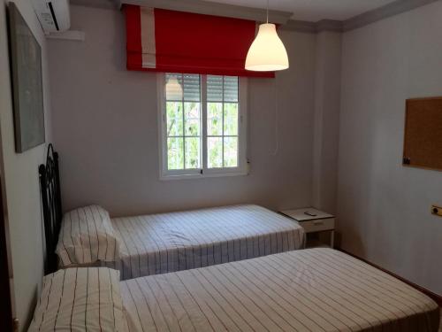 a bedroom with two beds and a window at Apartamento Olivia in Nerja