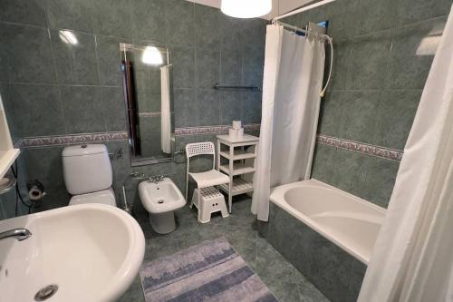 ein Badezimmer mit einer weißen Badewanne und einem Waschbecken und einer Toilette in der Unterkunft Casa do Vale - Moradia-Rio Minho-Seixas-Caminha - Casa de férias completa com piscina in Caminha