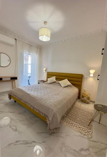 a bedroom with a large bed in a white room at Eleni's Green balcony modern apartment by the Sea in Loutraki