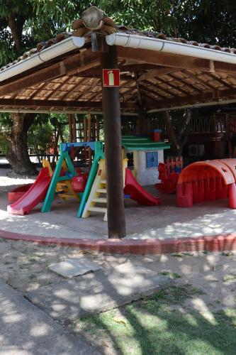 a playground in a park with a play structure at Bangalô Villas do Pratagy in Maceió