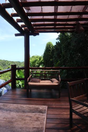 a wooden deck with a bench on top of it at Bangalô Villas do Pratagy in Maceió