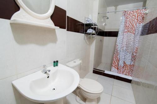 ピウラにあるConde Hotel Mirafloresの白いバスルーム(トイレ、シンク付)