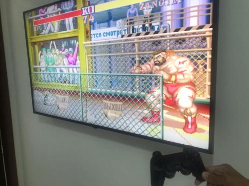 a tv hanging on a wall with a video game on it at BORA BORA RESIDENCE in Joinville