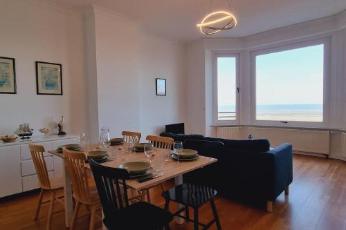 a living room with a table and a couch at l'Éclat du Littoral Vue mer - Good Home in Dunkerque