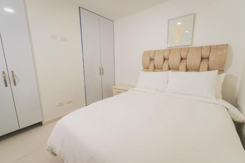 - une chambre blanche avec un grand lit et des placards blancs dans l'établissement Apartaloft en Pinares 8, à Pereira