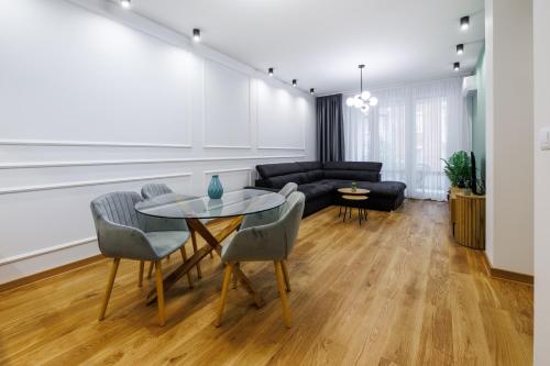 a living room with a table and chairs and a couch at Apartment Simpatico in Novi Sad