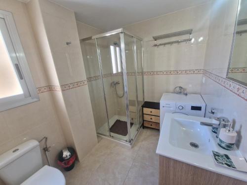 Un baño con ducha, lavabo e inodoro. en Piso Calpe Playa, en Calpe