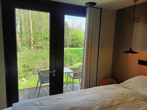 1 dormitorio con cama y vistas a un patio en Den Broecke, en Bornerbroek