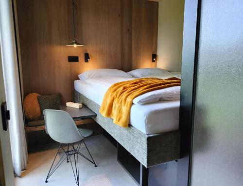 a bedroom with a bed with a desk and a chair at Den Broecke Studio in Bornerbroek
