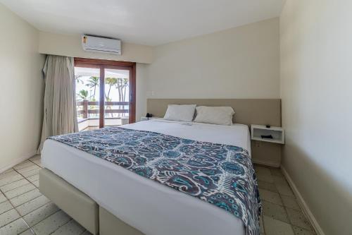 - une chambre avec un grand lit et un balcon dans l'établissement Flat beira-mar Jatiúca Resort by Slaviero, à Maceió
