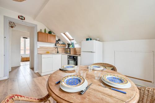 une cuisine avec une table en bois et des plaques de cuisson. dans l'établissement Le Splendide - Paris - Métro - 4 personnes, aux Lilas