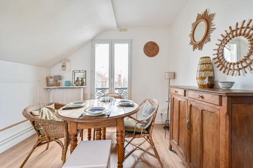 une salle à manger avec une table et des chaises en bois dans l'établissement Le Splendide - Paris - Métro - 4 personnes, aux Lilas