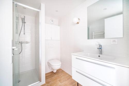 ein weißes Bad mit einem WC und einem Waschbecken in der Unterkunft Grand Studio Duplex Stade France in Aubervilliers