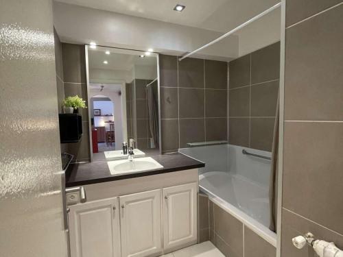 une salle de bain avec un lavabo et une baignoire dans l'établissement Charmant T2 avec terrasse, climatisé, centre-ville Antibes, proche mer et commerces - FR-1-252-177, à Antibes