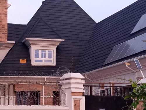 uma casa com um telhado preto com uma janela em Vincent Anene Estate, Nri em Amobia