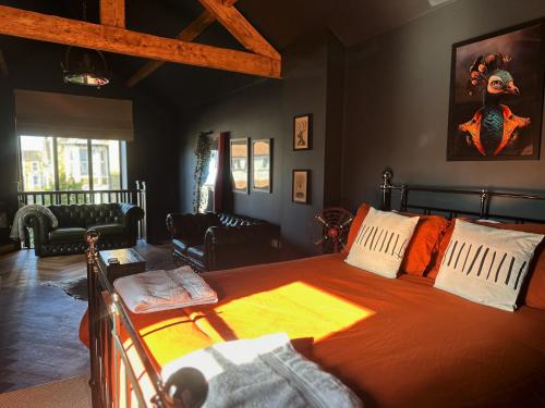 a bedroom with a bed with an orange bedspread at The Balmoral Coach House in Morecambe