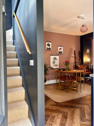 a staircase leading to a dining room with a table at The Balmoral Coach House in Morecambe