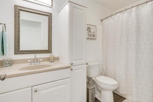 a bathroom with a toilet and a sink and a mirror at Charming Home with Patio 3 Mi to Hayden Lake! in Hayden