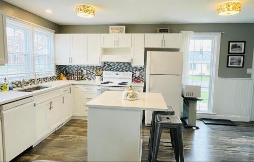 a kitchen with white cabinets and a white refrigerator at Mileva Retreats in Picton