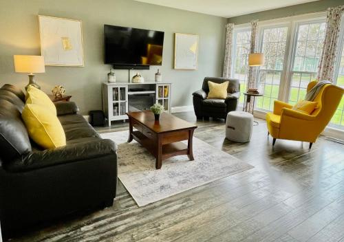 a living room with a couch and chairs and a tv at Mileva Retreats in Picton