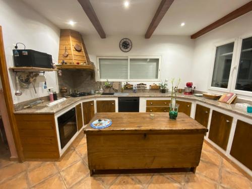 une cuisine avec un îlot en bois au milieu dans l'établissement Villa pour 4 personnes proche Santa Giulia, à Sotta