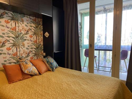 une chambre avec un lit avec des oreillers orange dans l'établissement Joli Studio rénové avec loggia fermée, tout équipé, WIFI, classé 2 étoiles à Balaruc-les-Bains - FR-1-553-161, à Balaruc-les-Bains