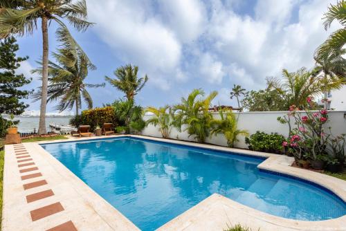 een zwembad in een villa met palmbomen bij Magnifica Villa Palmeras Pok ta Pok Zona Hotelera Cancun in Cancun