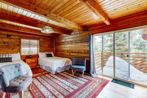 Dormitorio en cabaña de madera con 2 camas y ventana en Juniper Junction, en Park City