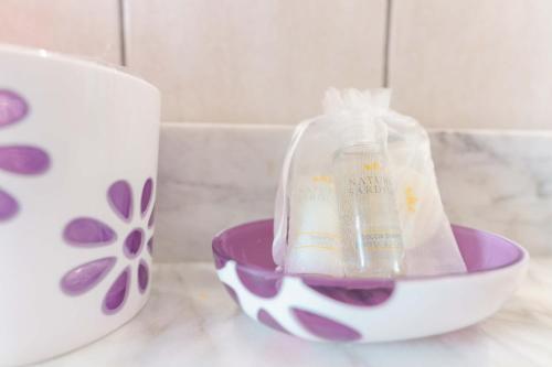 a bottle of soap in a bowl next to a mug at B&B Ametista in Villasimius