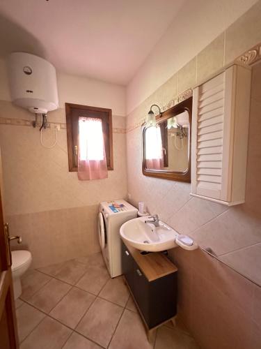 a bathroom with a sink and a toilet and a mirror at Il Girasole casa vacanze in Porto San Paolo