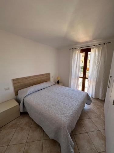 a bedroom with a bed and a large window at Il Girasole casa vacanze in Porto San Paolo