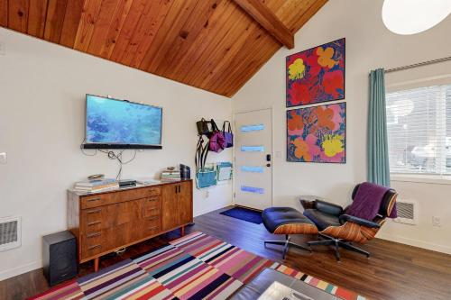 a living room with a tv and a chair and a dresser at The Sea Lion in Seaside
