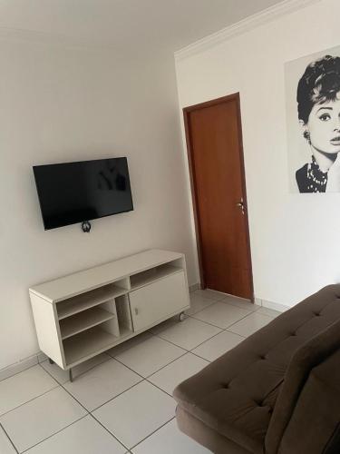 ein Wohnzimmer mit einem Sofa und einem Flachbild-TV in der Unterkunft Apartamento 2 quartos in Teixeira de Freitas
