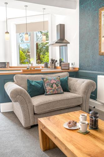 a living room with a couch and a table at Ashbrooke Apartment Keswick at The Lairbeck in Keswick