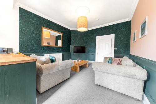 a living room with two couches and a television at Ashbrooke Apartment Keswick at The Lairbeck in Keswick