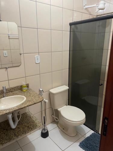 a bathroom with a toilet and a sink and a shower at Apartamento 2 quartos in Teixeira de Freitas