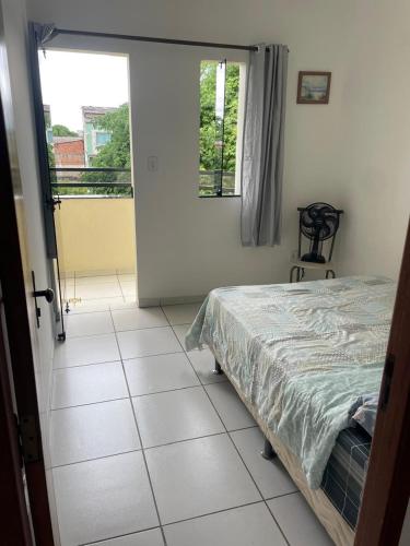 1 dormitorio con cama y ventana en Apartamento 2 quartos, en Teixeira de Freitas