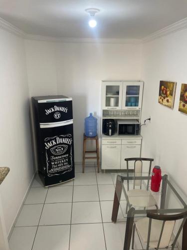 cocina con nevera, microondas y sillas en Apartamento 2 quartos, en Teixeira de Freitas