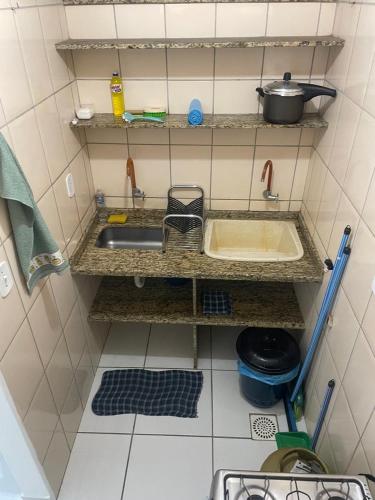 eine kleine Küche mit einer Spüle und einer Theke in der Unterkunft Apartamento 2 quartos in Teixeira de Freitas