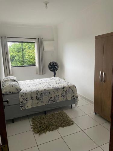 Schlafzimmer mit einem Bett und einem Fenster in der Unterkunft Apartamento 2 quartos in Teixeira de Freitas