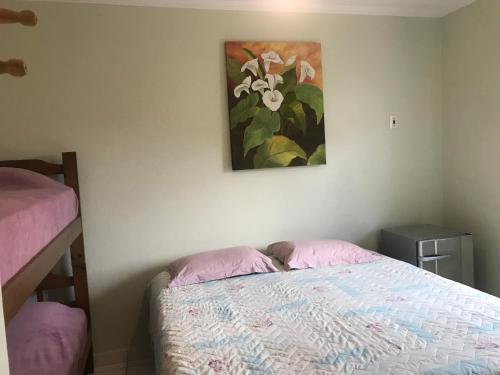 a bedroom with a bed and a painting on the wall at Pousada Movimentai in Boracéia